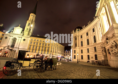 Pferdekutsche auf der asphaltierten Straße vor der Hofburg, Wien, Österreich Stockfoto