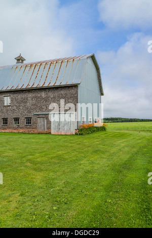 Alte, verwitterte schütteln Schindel doppelseitige Scheune mit verrosteten Metalldach Prince Edward Island, einer der die maritimen Provinzen in Kanada. Stockfoto