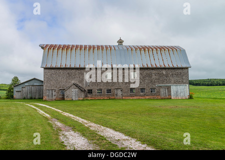 Alte, verwitterte schütteln Schindel doppelseitige Scheune mit verrosteten Metalldach Prince Edward Island, einer der die maritimen Provinzen in Kanada. Stockfoto