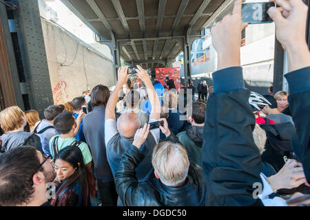 New York, USA. 18. Oktober 2013. Streetart-Fans strömen in West Chelsea Galerie Szeneviertel in New York die 18. Ausgabe von Banksy-Graffiti-Kunst, eine Zusammenarbeit mit den brasilianischen Künstlern, Os Gemeos sehen. Dieser Titel ist wie einer Museumsausstellung in eine Baulücke unter der High Line Park komplett mit "Museumswärter" Gruppenkontrolle behandeln eingerichtet. Die schwer fassbare Streetart-Künstler schafft Werke rund um die Stadt jeden Tag im Laufe des Monats Oktober. Bildnachweis: Richard Levine/Alamy Live-Nachrichten Stockfoto