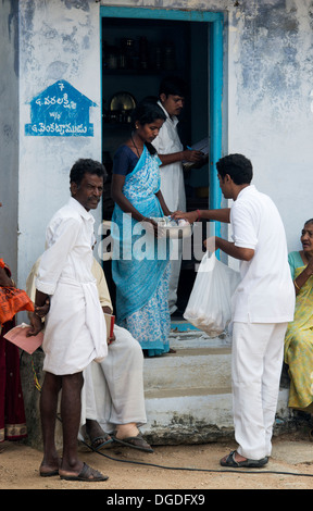 Indischen Sri Sathya Sai Baba College jungen verteilen Lebensmittel-Pakete bei Grama Seva in einem indischen Dorf.  Andhra Pradesh, Indien Stockfoto