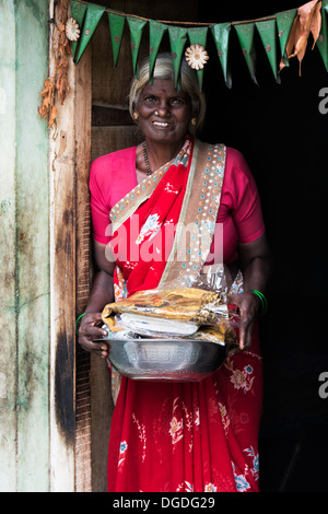 Indische Dorf Frau mit Geschenken von Nahrung und Kleidung von Sri Sathya Sai Baba Organisation gegeben. Andhra Pradesh, Indien Stockfoto