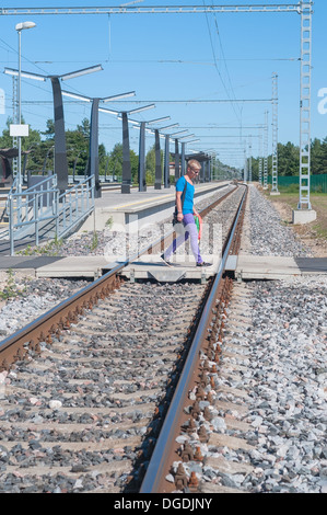 Mann zu Fuß über den Gleisen Stockfoto