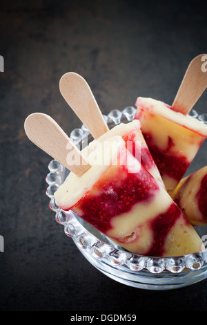 Hausgemachte Eis am Stiel mit Vanillepudding und Himbeeren Stockfoto