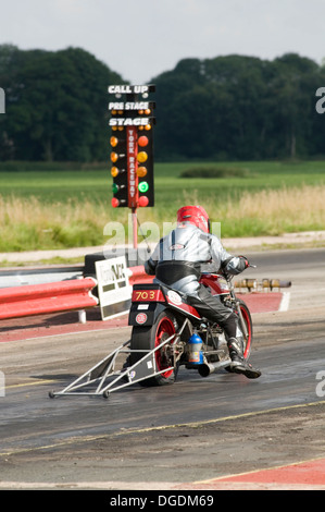 Motorrad Drag Racer verlassen die Startlinie nach Reaktion auf das grüne Licht auf den Weihnachtsbaum Stockfoto