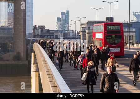 Am frühen Morgen Pendler cross London Bridge für die Stadt an einem kalten, sonnigen Wintermorgen Stockfoto