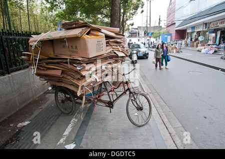 dreirädriges Fahrrad für die Kommissionierung von Altpapier und Kartonagen auf Straße in Shanghai, China Stockfoto