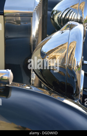 Thaxted Pfarrkirche spiegelt sich in der polierten Stirnlampe von einem Rolls Royce, Essex. Stockfoto