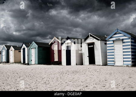 Stürmischer Himmel und Wolken hängen über Strandhütten an Southwold Strand in Suffolk. Stockfoto