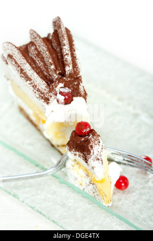 frische Ribes und geschlagene Sahne Dessert Kuchen Scheibe mit Kakaopulver obenauf Stockfoto