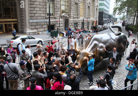 Touristen in New York City posiert mit der Aufladung Stier Skulptur nahe der Wall Street Stockfoto