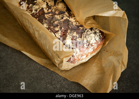 Handwerklichen Sauerteigbrot frisch aus dem Ofen in Wachspapier eingewickelt. Stockfoto