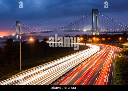 Verrazano-Narrows-Brücke über den Lichtspuren der Belt Parkway Verkehr. Stockfoto