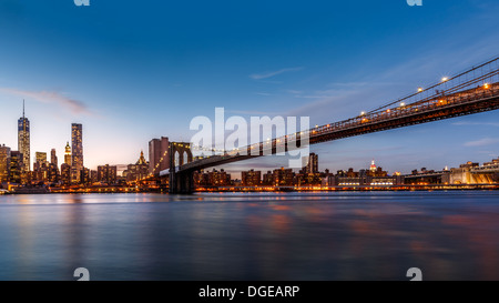 Brooklyn Bridge über den East River in der Abenddämmerung Stockfoto