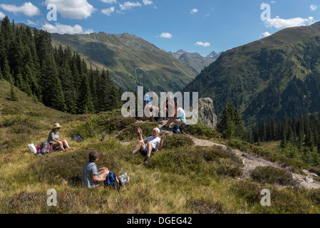 Eine kleine Gruppe von Erwachsenen Wanderer eine kurze Picknick Pause entlang der Madrisa Klosters Trail. Schweiz Stockfoto