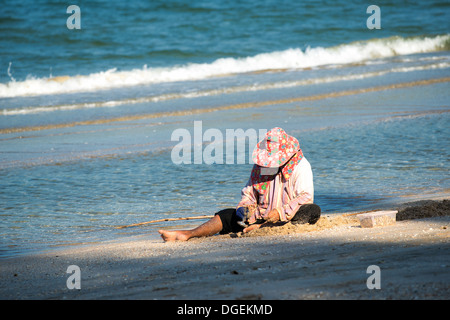 Thai Frau holt Muscheln am Strand südlich von Hua Hin Stockfoto