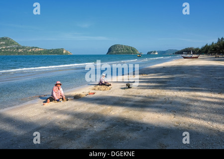 Thai-Frauen holen Muscheln am Strand südlich von Hua Hin Stockfoto