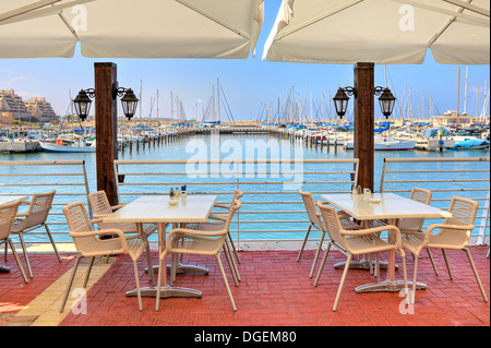 Weiße Tische und Stühle im Freien Restaurant auf Promenade Marina am Mittelmeer in Ashkelon, Israel. Stockfoto