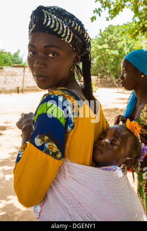 Junge Gambian Mutter tragen am Rücken, Fass Njaga Choi, North Bank Region, Gambia schlafenden Tochter. Stockfoto