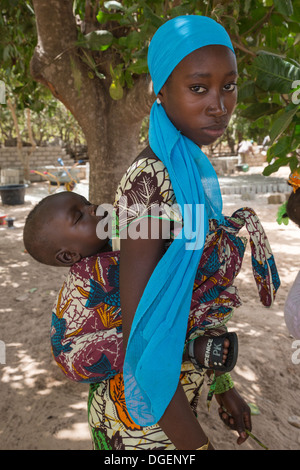 Junge Gambian Mutter mit schlafenden Sohn am Rücken, Fass Njaga Choi, North Bank Region, Gambia. Stockfoto