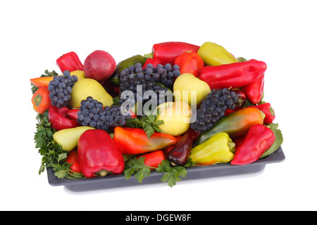 Reife Birnen, Äpfel, Trauben und Pfeffer auf einem Teller. Auf weißem Hintergrund dargestellt. Stockfoto