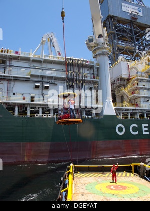 Besatzungsmitglieder der Bohrinsel wurde transportiert auf einem Korb zu einem Lieferung/Transport-Schiff an der Küste von Rio De Janeiro, Brasilien Stockfoto