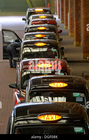 Blick aus der Vogelperspektive auf die Warteschlange mit schwarzem Londoner Taxi im Bahnhof Liverpool Street, die auf Kunden warten, England Großbritannien Stockfoto