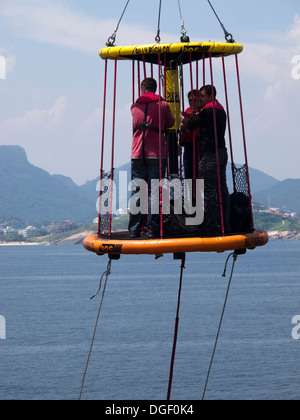 Besatzungsmitglieder der Bohrinsel wurde transportiert auf einem Korb zu einem Lieferung/Transport-Schiff an der Küste von Rio De Janeiro, Brasilien Stockfoto