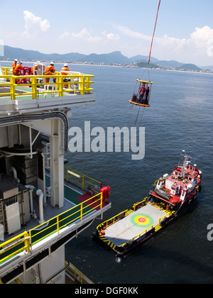 Besatzungsmitglieder der Bohrinsel wurde transportiert auf einem Korb zu einem Lieferung/Transport-Schiff an der Küste von Rio De Janeiro, Brasilien Stockfoto