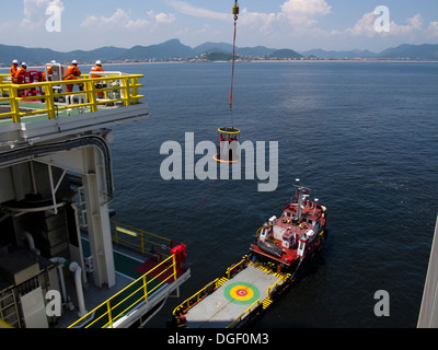 Besatzungsmitglieder der Bohrinsel wurde transportiert auf einem Korb zu einem Lieferung/Transport-Schiff an der Küste von Rio De Janeiro, Brasilien Stockfoto