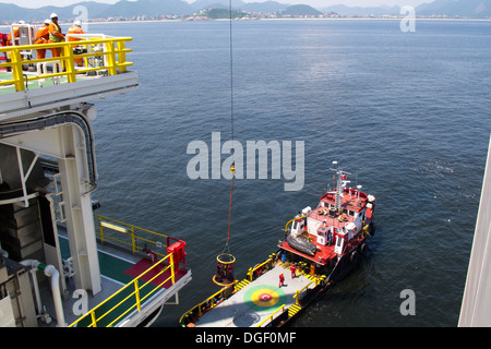 Besatzungsmitglieder der Bohrinsel wurde transportiert auf einem Korb zu einem Lieferung/Transport-Schiff an der Küste von Rio De Janeiro, Brasilien Stockfoto