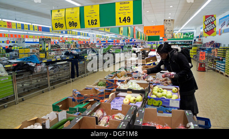 Eine Frau, die Obst und Gemüse kauft, schaut sich an Kästen mit Äpfeln in einem deutschen Lidl-Supermarkt billiges Essen Geschäft in Großbritannien KATHY DEWITT Stockfoto