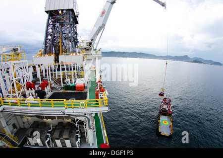 Besatzungsmitglieder der Bohrinsel wurde transportiert auf einem Korb zu einem Lieferung/Transport-Schiff an der Küste von Rio De Janeiro, Brasilien Stockfoto