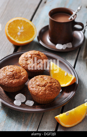 Karotten-Muffins mit frischen Orangen Früchten auf hölzernen Hintergrund Stockfoto