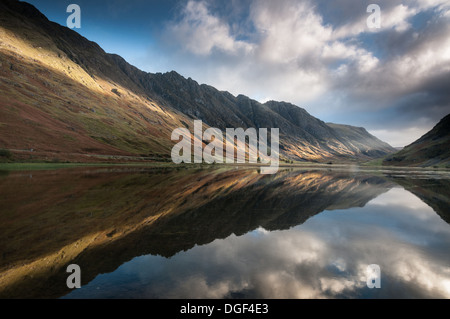 Platzen der Sonneneinstrahlung auf der Seite der Aonach Eagach Ridge und Loch Achtriochtan, Glencoe, Schottisches Hochland, Schottland Stockfoto