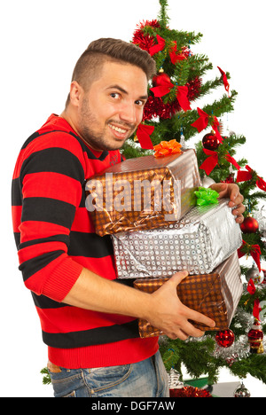 Lustiger Mensch mit Stapeln von Weihnachten präsentiert vor Baum wollen Stola Stockfoto