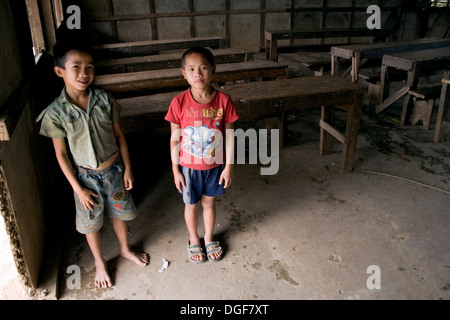 Zwei jungen stehen in der Nähe der Tür ihrer spärlichen Unterricht an einer Grundschule in Ban Bumlao, der Provinz Luang Prabang, Laos. Stockfoto
