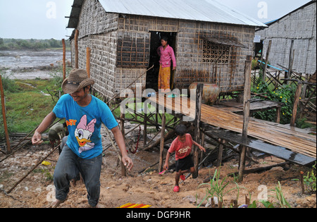 Eine kambodschanische Familie im Regen auf das schwimmende Dorf am Tonle Sap See in der Nähe von Siem Reap, Kambodscha. Stockfoto