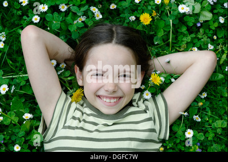 Mädchen liegend auf einer Blumenwiese, Upper Bavaria, Bavaria, Germany Stockfoto