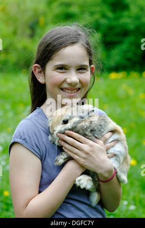 Mädchen hält ein Zwerg-Kaninchen, Upper Bavaria, Bavaria, Germany Stockfoto