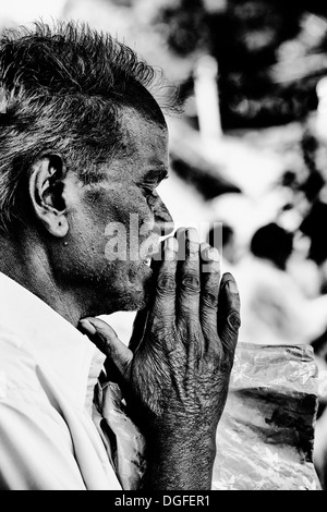 Indischer Mann im Gebet während der Wartezeit auf Sri Sathya Sai Baba mobile aufsuchende Krankenhaus zu sehen. Andhra Pradesh, Indien Stockfoto