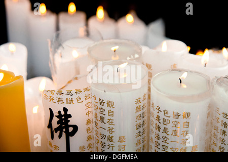 Kerzen in einem Tempel. Der Text auf die Kerzen ist das Herz des Prajna Paramita Sutra. Stockfoto