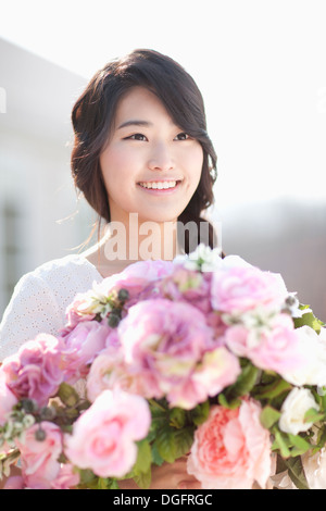 eine junge Frau mit schönen Blumen Stockfoto