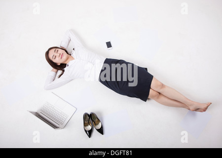 eine Geschäftsfrau neben Laptop mit Schuhen Stockfoto