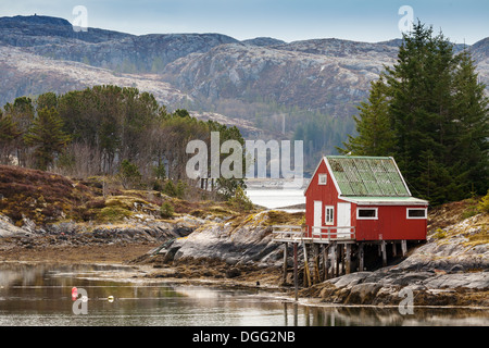 Rotes Holzhaus steht am Meer in Norwegen Stockfoto