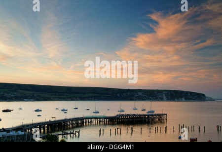 Sonnenuntergang über Ballard Punkt, alte & neuen Pier in Swanage Bay, Swanage, Dorset, Großbritannien Stockfoto