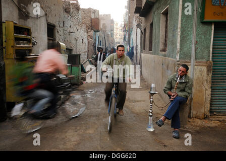 Radfahrer und ein ägyptischer Mann Rauchen einer Wasserpfeife, historische Stadtzentrum von Luxor, Nil Senke, Ägypten, Afrika Stockfoto