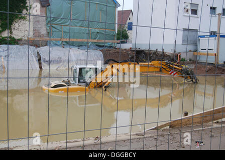 Bagger in eine Baugrube, die überflutet, wird geparkt, Überschwemmungen, Hochwasser in Ludwigsburg District, Ditzingen, Baden-Württemberg Stockfoto