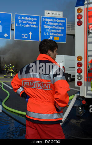 Eine Rettung Service Intern ist einen LKW auf der Autobahn A8 in der Nähe der Kreuzung "Echterdinger Ei", Stuttgart Feuer beobachten. Stockfoto