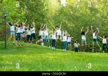 Große Gruppe von Kindern im Park springen Stockfoto